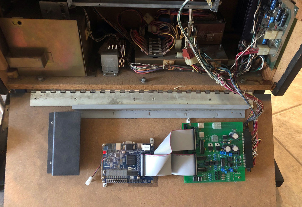 The v2 prototype, consisting of an FPGA development board, and an interface board for handling power, audio, controls, and display, running in an Asteroids cocktail cabinet